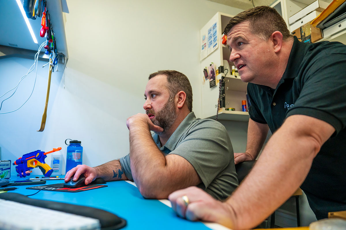 iResQ - Two technicians at a desk on the computer