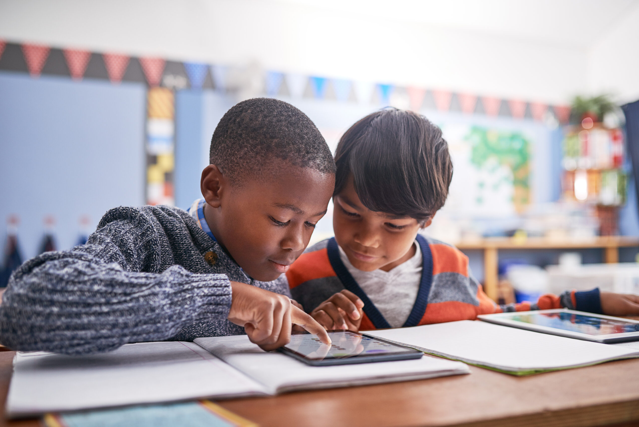 Two boys looking at a tablet in class
